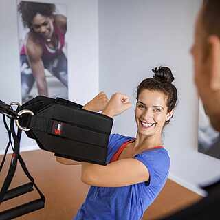 Frau beim GroupFitness mit Trainer